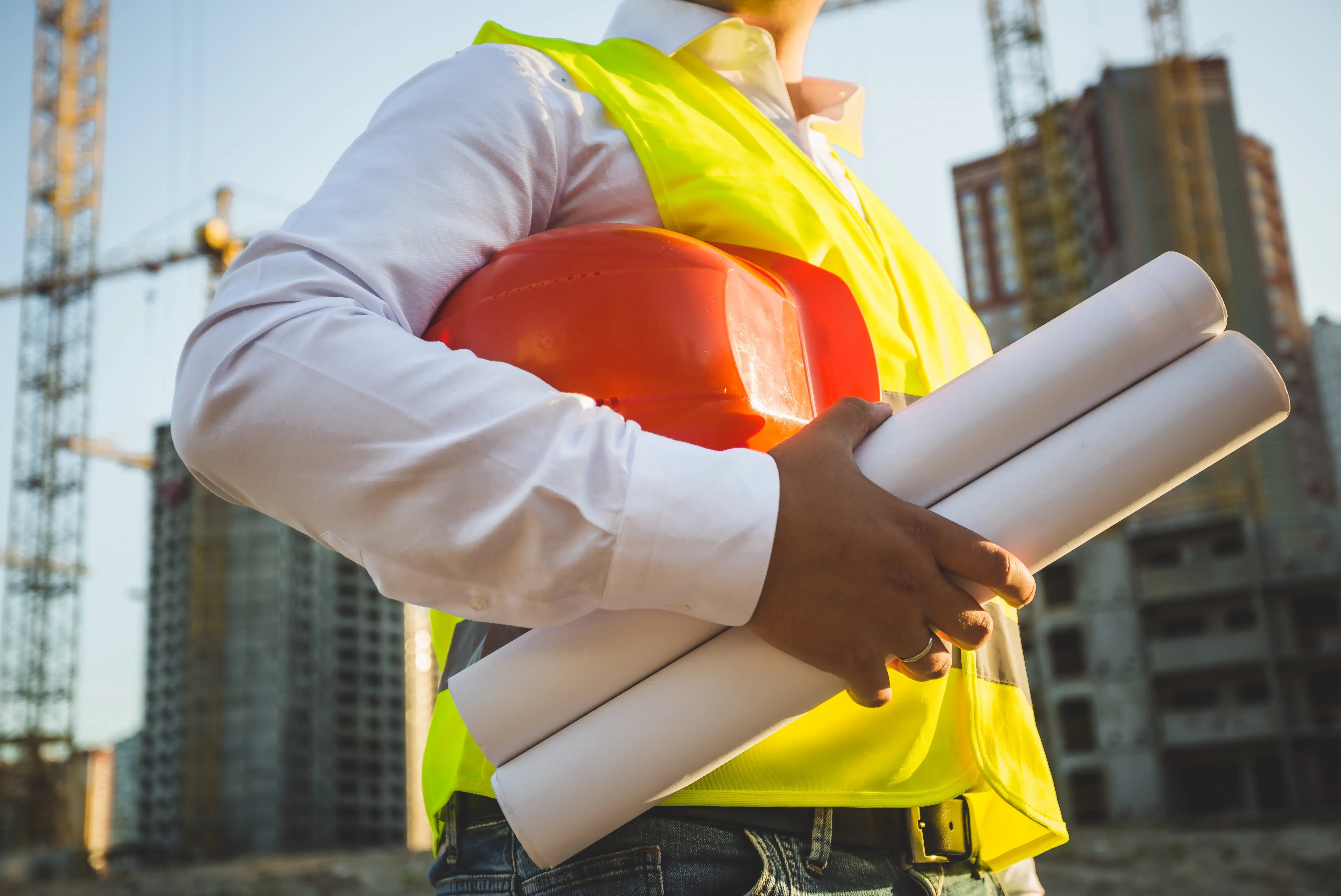 construction-engineer-holding-hardhat-and-blueprint