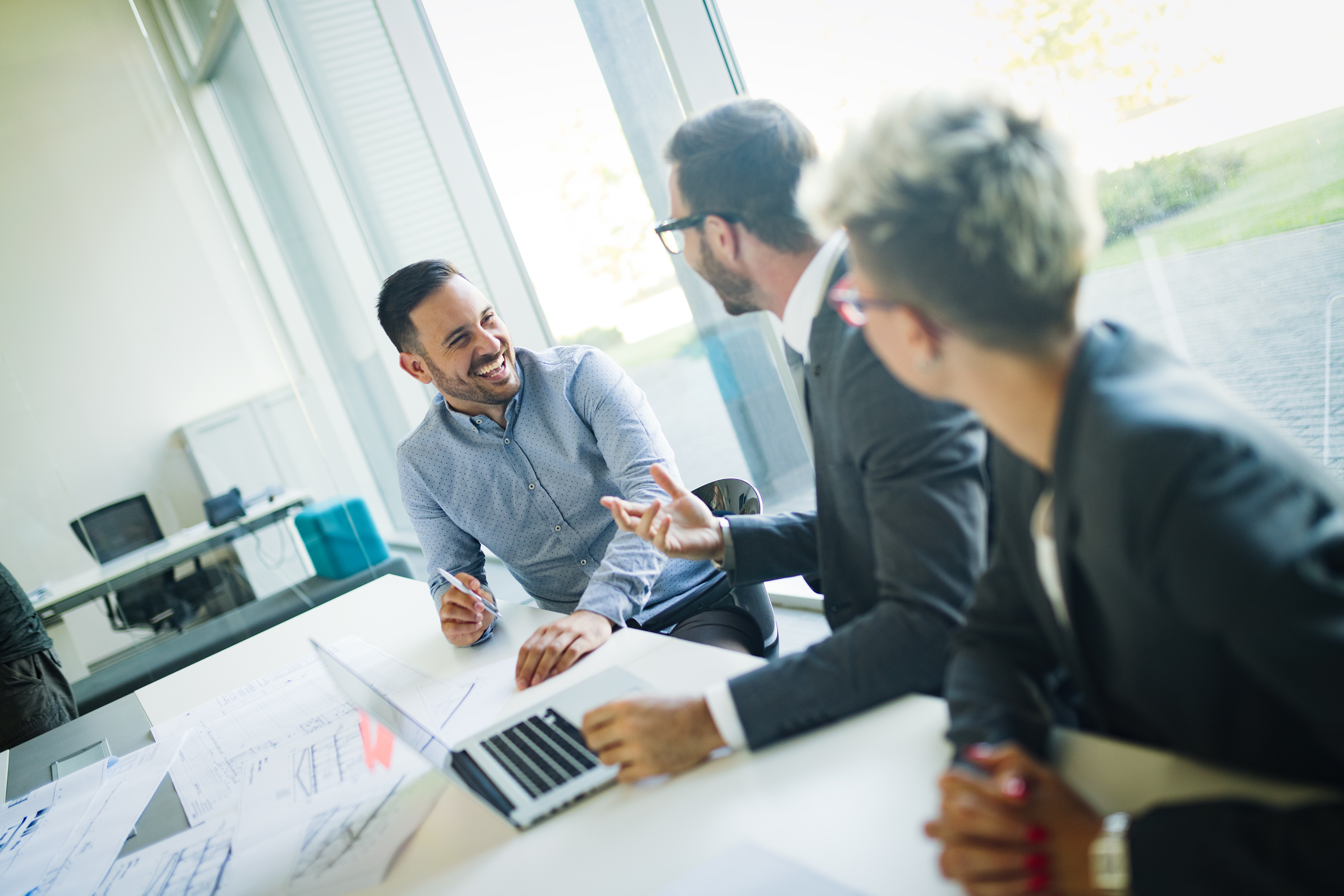 Business professionals in a meeting discussing company documents, understanding how to find a company registration number for UK businesses.