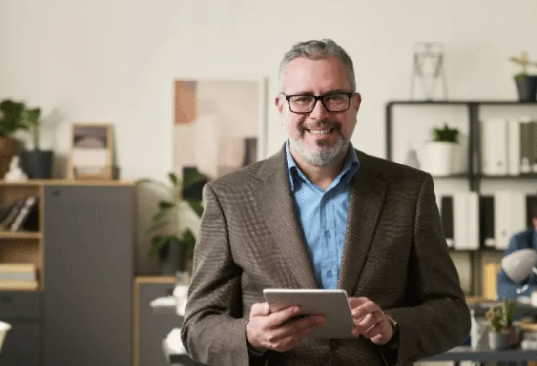 Professional business director holding a tablet in an office, representing limited company essentials and guidance for new directors.