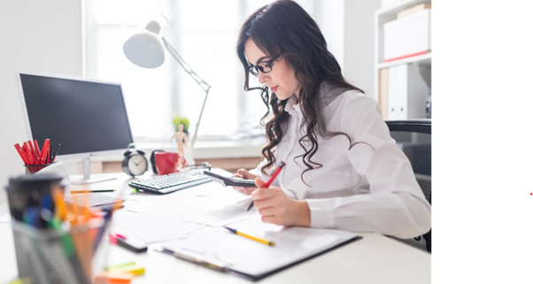 Woman calculating financial figures with documents and calculator while reviewing goodwill in accounting for business valuation.