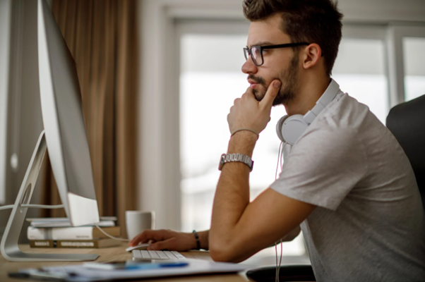 Business professional reviewing tax compliance on desktop while preparing to register for self assessment in the UK.