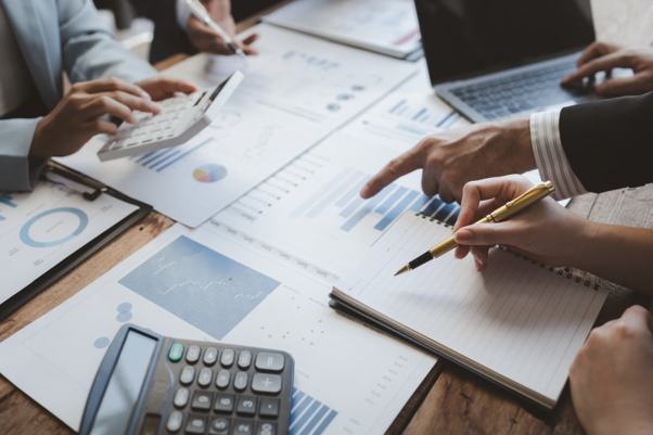 Professionals comparing financial reports and discussing accountancy packages to evaluate business accounting services.